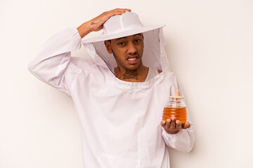 Young African American beekeeper isolated on white background being shocked, she has remembered important meeting.