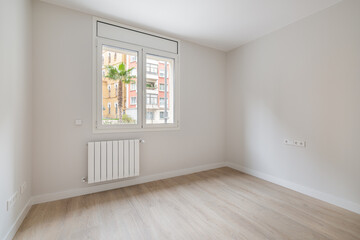 Empty white room with heating and window with city view. Interior of a modern apartment.