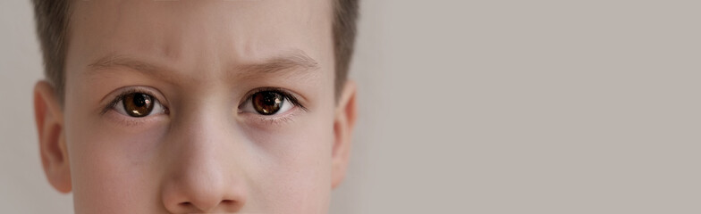 close-up of part of the child's face, boy 8-10 years old Asian-European appearance, human eye looking seriously at the camera, the concept of surveillance, peeping, tracking