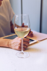 Young woman drinks wine while scrolling on tablet