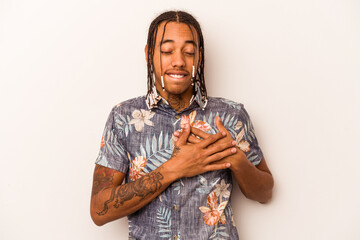 Obraz premium Young African American man isolated on white background has friendly expression, pressing palm to chest. Love concept.