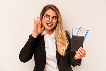 Young business caucasian woman holding a passport isolated on white background trying to listening a gossip.
