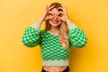 Young caucasian woman isolated on yellow background excited keeping ok gesture on eye.