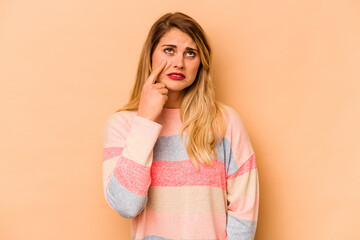 Young caucasian woman isolated on beige background crying, unhappy with something, agony and confusion concept.