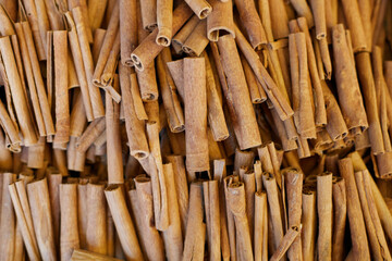 Cinnamon background. Pile of cinnamons stick on market