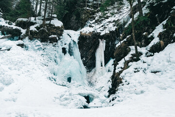 Winter waterfall with frozen water and snow