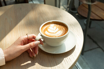 girl holding cup of coffee at the table