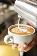 barista pouring cup of coffee