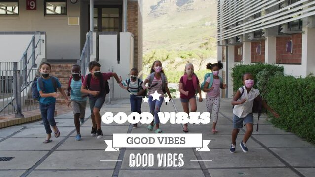 Animation of good vibes text over diverse schoolchildren running with face masks