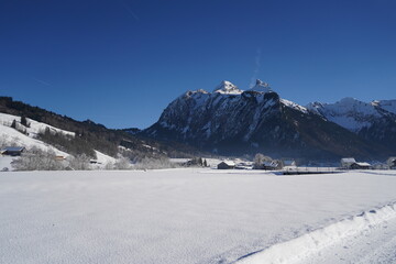 Village Studen, Switzerland in winter. It is situated among snow covered fields with mountains on...