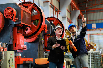lathe and stamping metal machine. Caucasian business man and Factory engineer in hard hat helmet...