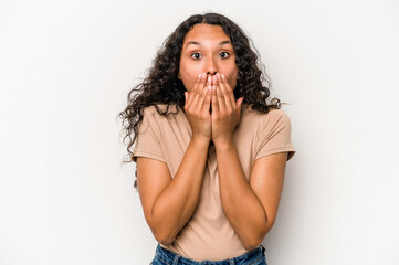 Young hispanic woman isolated on white background shocked covering mouth with hands.