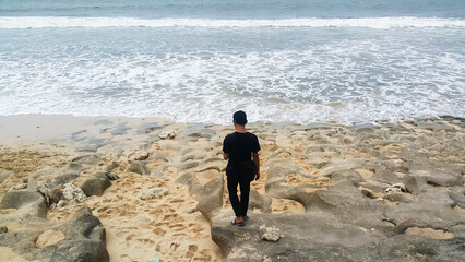 a man walking towards the beach