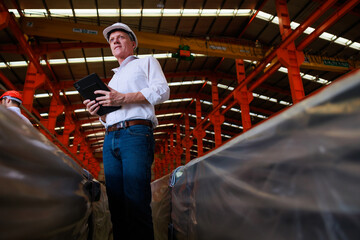 Portrait professional Design civil engineer wearing safety hardhat helmet holding digital tablet computer in large Industrial Factory. Small business owner.