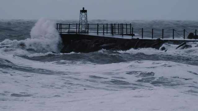 Hurricane Causing Waves To Crash Over Rocks And Pier