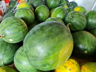 Many big sweet green watermelons and one cut watermelon