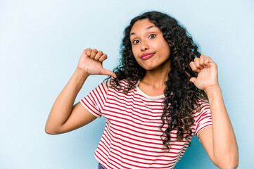 Young hispanic woman isolated on blue background feels proud and self confident, example to follow.