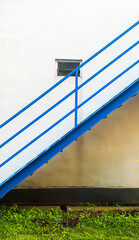 stairs made of iron with bright blue paint, leading to the tennis court