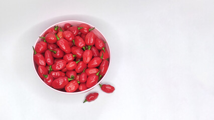 Red peppers in the bowl with white background. Space for text