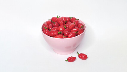 Red peppers in the bowl with white background. Space for text