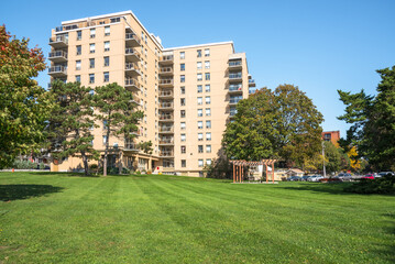 Apartment building at the far end of a well-tended lawn on a clear autumn day
