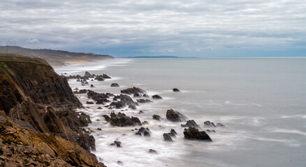 Fototapeta na wymiar long exposure vertical view of rocky and wild coast on the Altlantic Ocean
