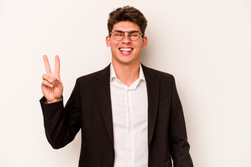 Young caucasian business man isolated on white background joyful and carefree showing a peace symbol with fingers.