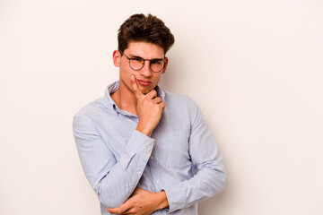 Young caucasian man isolated on white background unhappy looking in camera with sarcastic expression.