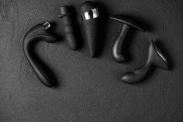 Erotic pleasure toys on a black background. Sex gadgets and masturbation devices. Pink dildo...