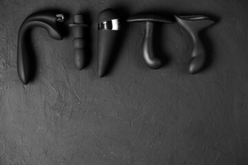 Erotic pleasure toys on a black background. Sex gadgets and masturbation devices. Pink dildo...