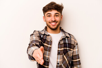 Young hispanic man isolated on white background stretching hand at camera in greeting gesture.