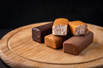Different glazed cottage cheese bars on black background.