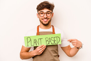 Young gardener man holding plant based placard isolated on white background