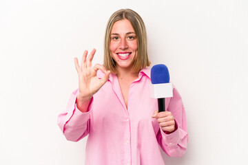 Young caucasian journalist woman isolated on white background cheerful and confident showing ok gesture.