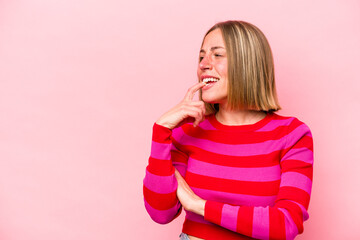 Young caucasian woman isolated on pink background relaxed thinking about something looking at a copy space.