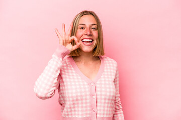 Young caucasian woman isolated on pink background cheerful and confident showing ok gesture.