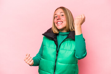 Young caucasian woman isolated on pink background cheering carefree and excited. Victory concept.