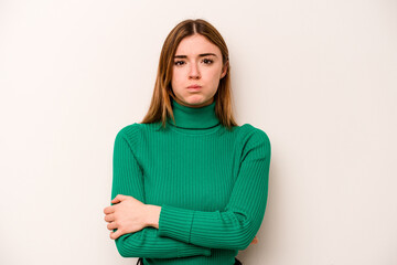Young caucasian woman isolated on white background blows cheeks, has tired expression. Facial...