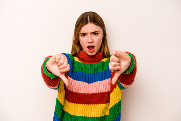 Young caucasian woman isolated on white background showing thumb down and expressing dislike.