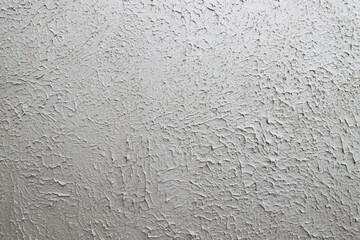 The grainy texture of wall plaster.