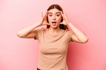 Young caucasian woman isolated on pink background receiving a pleasant surprise, excited and raising hands.