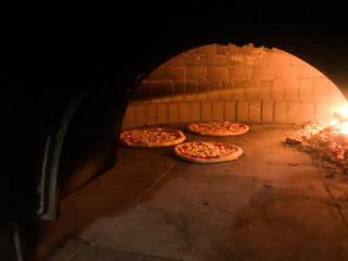 Wood oven with pizza being cooked