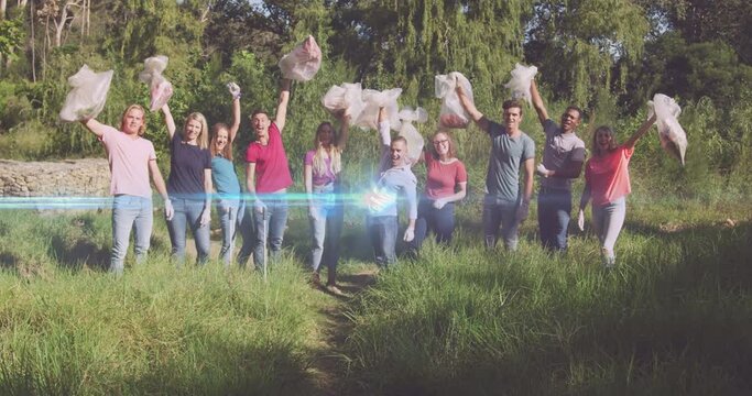 Video of lights over cheering diverse volunteer group picking up rubbish in countryside
