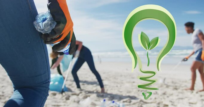 Animation of go green light bulb logo over diverse group picking up rubbish from beach