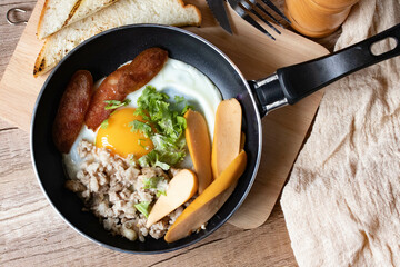 English breakfast with fried egg with minced pig and sausage (Thai called kai Kara) served in a small pan