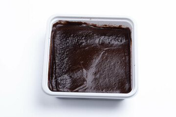 Chocolate cake is shown in a square box.On a white background.