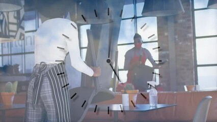 Animation of clock over diverse couple working in face masks - Powered by Adobe