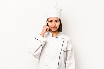 Young hispanic chef woman isolated on white background pointing temple with finger, thinking, focused on a task.