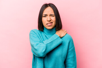 Young hispanic woman isolated on pink background having a shoulder pain.