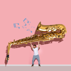 Creative design. Young man holding giant golden trumpet isolated over pink background